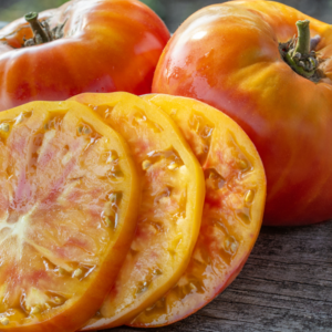 Close-up of yellow heirloom tomatoes, whole and sliced.
